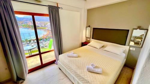 a bedroom with a bed and a large window at Atlantis Hotel in Agios Nikolaos