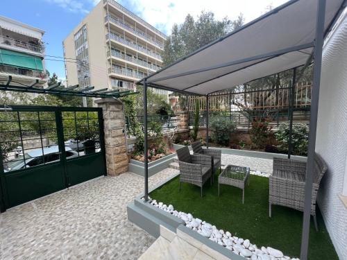 eine Terrasse mit einem Tisch, Stühlen und einem Sonnenschirm in der Unterkunft Riviera-MelRod-Athens in Athen