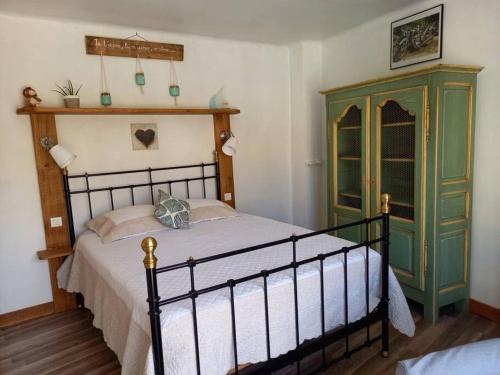 a bedroom with a bed and a green cabinet at Comps sur Artuby, le tilleul et le four, Jabron in Comps-sur-Artuby