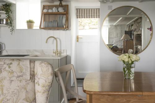 a dining room with a table and a mirror at Mariners Cottage in Mousehole