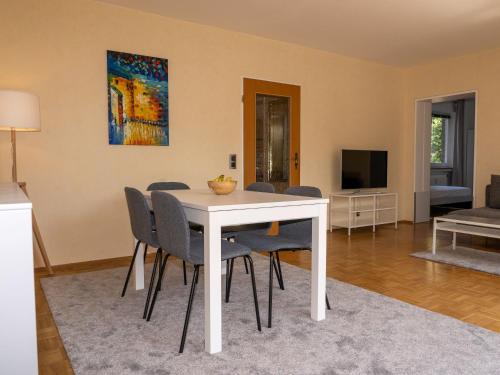 - un salon avec une table et des chaises blanches dans l'établissement 199 Fewo Havenbrücke, à Wilhelmshaven