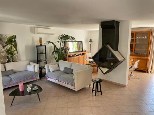 a living room with two couches and a flat screen tv at Villa piscine privée in Carry-le-Rouet