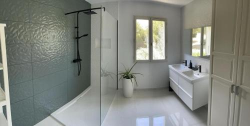 a bathroom with a glass shower and a sink at Villa piscine privée in Carry-le-Rouet