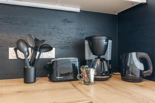 - un comptoir de cuisine avec des appareils sur un comptoir en bois dans l'établissement Full House By Plaza, à Chessy