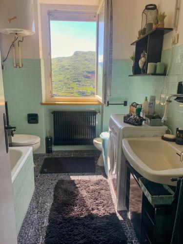 a bathroom with a sink and a toilet and a window at Villa Magnolia Oliveti in Crosano