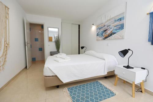 - une chambre avec un lit blanc et un tapis bleu dans l'établissement Z - Gil Vicente Guest Rooms, à Lagos