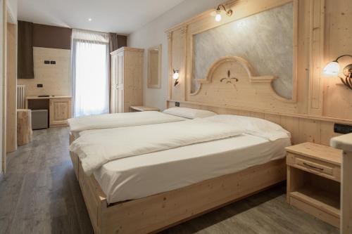 レードロにあるHotel Garni Minigolfの広いベッドルーム(ベッド2台付)、キッチンが備わります。