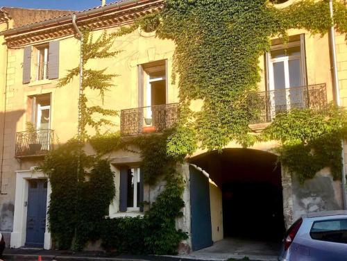 an ivy covered building with a car parked in front at Grand studio indépendant in Paulhan