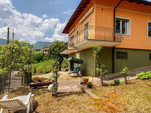 ein Haus mit einem Balkon und Stühlen im Hof in der Unterkunft Villa Magnolia in Crosano