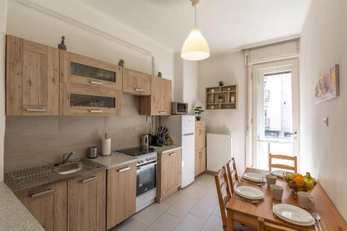 a kitchen with wooden cabinets and a wooden table with a dining room at Best Location, Family friendly Panorama view by NW in Budapest