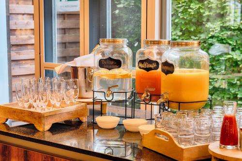 a counter with glasses and bottles of orange juice at Welcome Hotel Bad Arolsen in Bad Arolsen