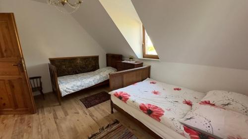 a bedroom with two beds with flowers on them at Dom w sercu Kaszub in Parchowo