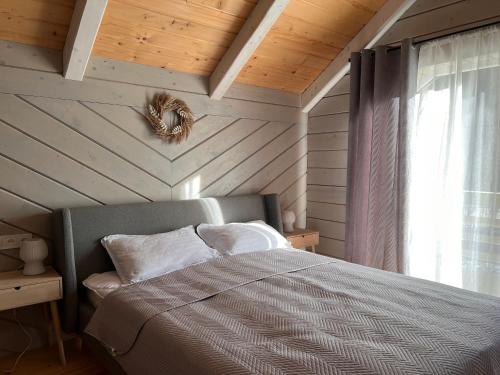 a bedroom with a bed and a wooden wall at Апартаменти БАРВА in Beloberëzka