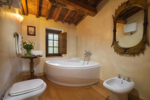 a bathroom with a tub and a toilet and a sink at PODERE SANTA CROCE 10, Emma Villas in Radicondoli