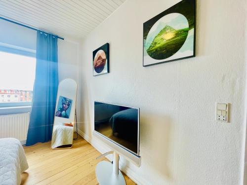 um quarto com uma televisão de ecrã plano na parede em aday - Modern charming apartment in Noerresundby em Nørresundby