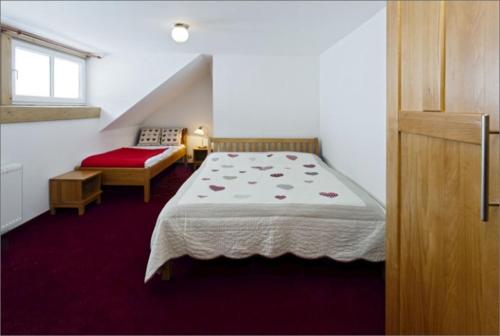 a small bedroom with a bed and a window at Penzion Marienka in Pec pod Sněžkou