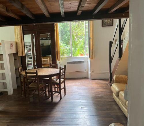 une salle à manger avec une table et des chaises et une fenêtre dans l'établissement Villa Bourgoise chez Perette à 7 mn en voiture de la croisette, à Cannes