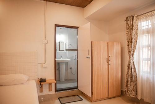 a small bathroom with a shower and a sink at MOCAHM in Shillong