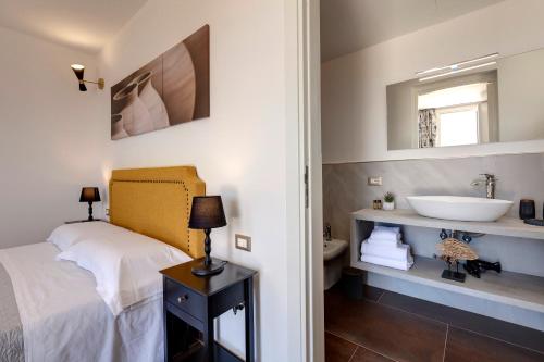uma casa de banho com uma cama e um lavatório em Together In Salento em Morciano di Leuca