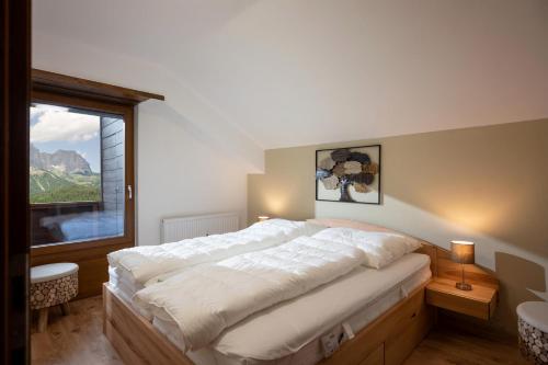 um quarto com uma cama grande e uma janela grande em Ellmauer Auszeit em Ellmau