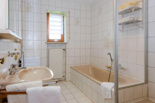 ein Badezimmer mit einer Badewanne und einem Waschbecken in der Unterkunft Ferienwohnung-Panoramablick -4 in Bodenmais