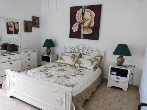 1 dormitorio con 1 cama blanca con 2 lámparas y TV en KATKA Karavas, en Citera