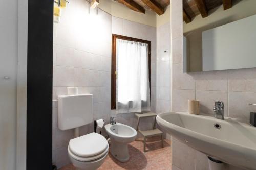 ein Badezimmer mit einem weißen WC und einem Waschbecken in der Unterkunft A due passi della casa natale del Maestro Toscanini in Parma