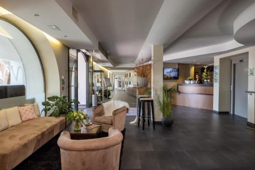a lobby with a couch and chairs and a bar at Hôtel Val-Vignes Colmar Haut-Koenigsbourg, The Originals Relais in Saint-Hippolyte