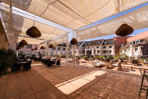 un patio al aire libre con mesas, sillas y luces en Hotel Antequera Hills, en Antequera