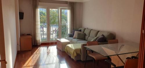 ein Wohnzimmer mit einem Sofa und einem Tisch in der Unterkunft Piso Parque Eguren in Marín