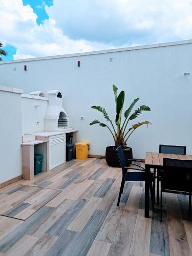 a room with a table and a potted plant at Pescoluse Apartments in Marina di Pescoluse