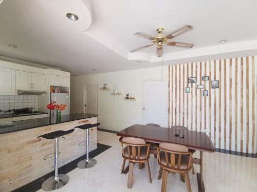 a kitchen with a table and chairs and a ceiling fan at Pool Villa 92 in Ban Nong Pru