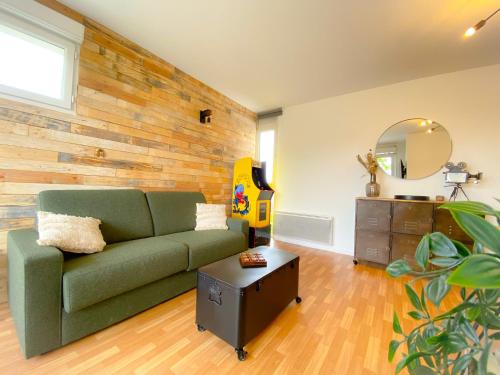 - un salon avec un canapé vert et une commode dans l'établissement L'Arcade, à Calais