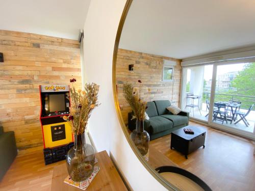 un salon avec un canapé et un miroir dans l'établissement L'Arcade, à Calais