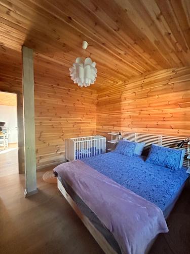 um quarto com uma cama e uma parede de madeira em I - Apartament na Warmi dla rodzin z dziećmi em Gietrzwałd