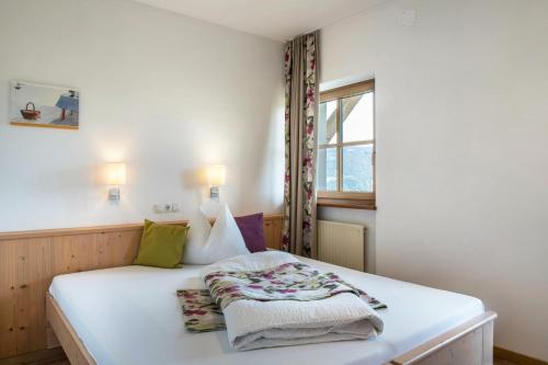 Schlafzimmer mit einem Bett mit weißer Bettwäsche und einem Fenster in der Unterkunft Rotkäppchen Schlosshof in Umes