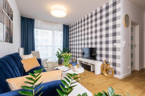 a living room with a blue couch and a tv at Deluxe Apartments by The Railway Station Wroclaw in Wrocław
