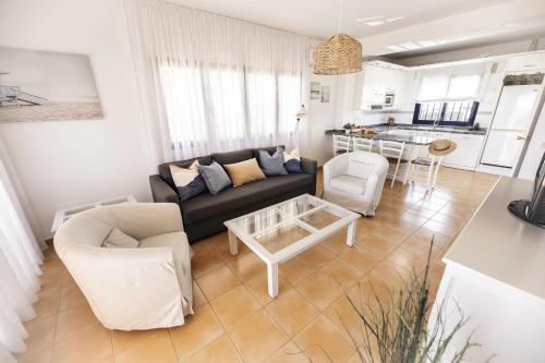 een woonkamer met een bank, stoelen en een tafel bij Bahía Meloneras Playa 1 in Meloneras