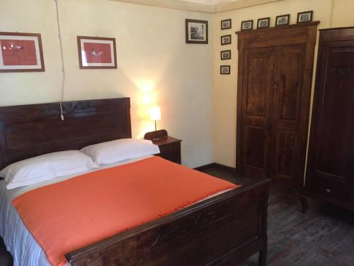 a bedroom with a bed with an orange blanket at Entroterra Langa in Borgomale