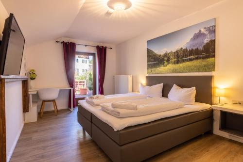a bedroom with a large bed with a large painting on the wall at Gasthof zur Post Saulgrub in Saulgrub