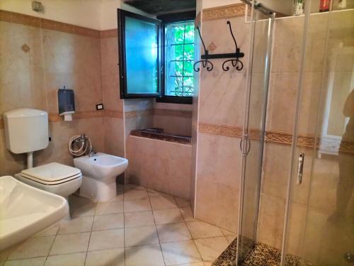 y baño con aseo, ducha y lavamanos. en Agriturismo Casa Rastelli, en Monteorsello