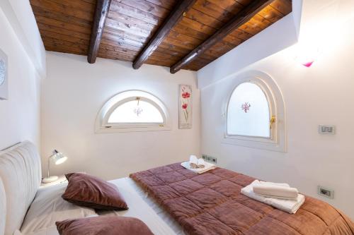 um quarto com uma cama grande e 2 janelas em Villa Cormorano em Olbia
