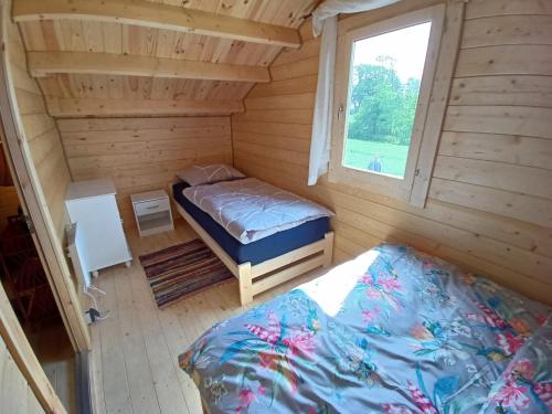 a small room with two beds and a window at Świerkowe Siedlisko in Węgorzewo