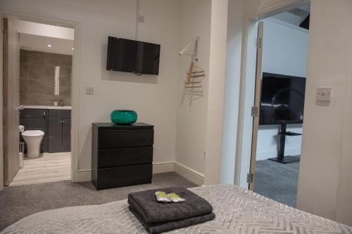 1 dormitorio con cama, TV y baño en #5 Grimston St Apartment near Hull New Theatre and Connexin Live en Hull