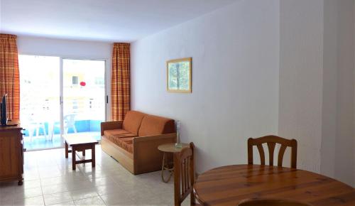een woonkamer met een bank en een tafel bij Apartamentos Zahara Palmyra in Salou
