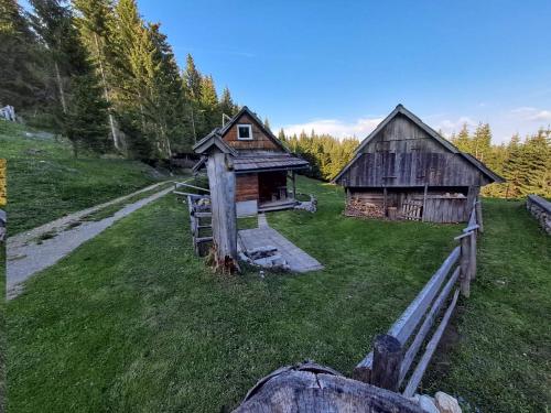 uma vista aérea de dois edifícios de madeira num campo em Koča na planini Jelje - Pokljuka em Goreljek