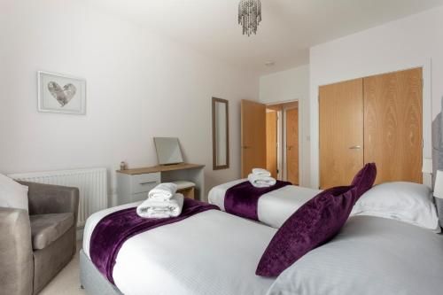 Duas camas numa sala de estar com um sofá em Belfry Quarters, Redhill em Redhill