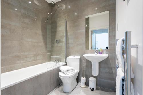 ein Bad mit einem WC, einem Waschbecken und einer Dusche in der Unterkunft Belfry Quarters, Redhill in Redhill
