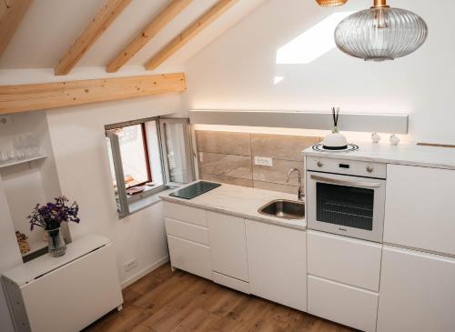 a kitchen with white cabinets and a sink at Wilena Apartments in Piran