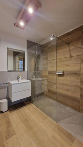 Un baño con ducha de cristal y lavabo. en Appartamento Col Val di Fassa con giardino BAGNI RINNOVATI 2023, en Campitello di Fassa